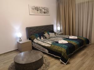 - une chambre avec un lit et une table basse dans l'établissement Sunrise Studio - DeSilva Residence Mamaia Nord, à Mamaia