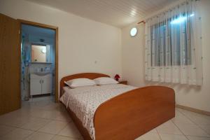 a bedroom with a bed and a bathroom with a sink at Holiday house Silvana in Ždrelac