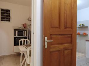 uma porta de madeira numa cozinha com uma mesa em Appartement Camillia, 41m2 et son jardin privatif. em Petit-Bourg