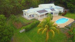 uma vista aérea de uma casa com piscina em Appartement Camillia, 41m2 et son jardin privatif. em Petit-Bourg