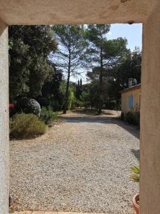 vista su un vialetto con una casa e alberi di LES PAPILLONS a Flassans-sur-Issole