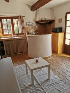 ein Wohnzimmer mit einem Tisch und einer Küche in der Unterkunft LES PAPILLONS in Flassans-sur-Issole