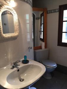 ein Badezimmer mit einem Waschbecken, einem WC und einem Spiegel in der Unterkunft LES PAPILLONS in Flassans-sur-Issole