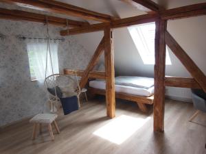 um quarto com uma cama de baloiço e uma cadeira em Landhaus Huchatz em Burg