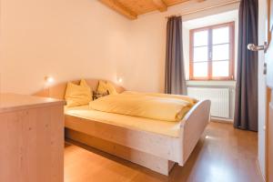 ein Schlafzimmer mit einem Holzbett in einem Zimmer in der Unterkunft Brugger Hof in Feldthurns
