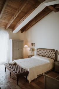 a bedroom with a large bed with a bench in it at Parco di Montebello in Quattro Castella