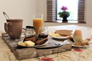 una mesa con pan y queso y un vaso de zumo de naranja en Naturaliterre BnB - Microfattoria, en Dovadola