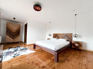 een slaapkamer met een bed en een houten vloer bij PANORAMIC Sus In Deal in Vişeu de Jos +58 foto's