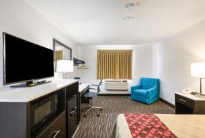 ein Hotelzimmer mit einem Bett und einem Flachbild-TV in der Unterkunft Americas Best Value Inn Charlotte in Charlotte