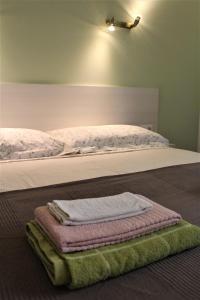 een bed met drie vouwhanddoeken erop bij Naturaliterre BnB - Microfattoria in Dovadola