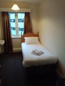 a small bed in a room with a window at Black Lion in Scarborough