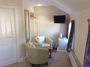 a living room with a chair and a television at The Village Inn in Kirtlebridge