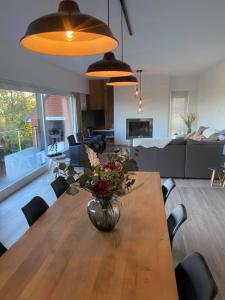 un jarrón de flores sobre una mesa de madera en la sala de estar en Het Kastanjehuis en Orlitain