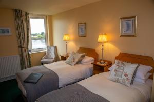 a hotel room with two beds and a window at Coastline House in Dingle