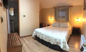 1 dormitorio con cama blanca y ventana en Hostal Graciela en Pucón