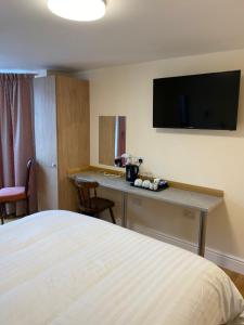 a hotel room with a bed and a desk with a television at The Grand Harbour hotel in Ilfracombe