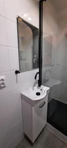 a white bathroom with a sink and a mirror at Aleda Kaskada in Szczecin +8 photos