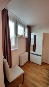 a living room with a chair and a window at Aleda Kaskada in Szczecin