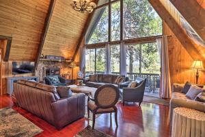 ein Wohnzimmer mit Ledermöbeln und einem großen Fenster in der Unterkunft A-Frame Home with 3 Decks and Lake Arrowhead Views! in Lake Arrowhead