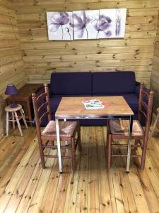 a table and chairs with a blue couch in a room at gite Labarcarole in Lillers