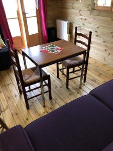 a wooden table and chairs in a living room at gite Labarcarole in Lillers