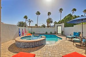 a swimming pool with a table and an umbrella at Adobe Escape with Private Spa and Pool in La Quinta! in La Quinta