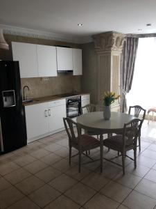 a kitchen with a table and chairs and a kitchen with white cabinets at Columba Livia Guesthouse in Palanga