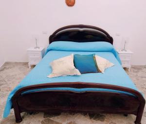 a bedroom with a bed with blue sheets and pillows at Cetara Sunny House in Cetara