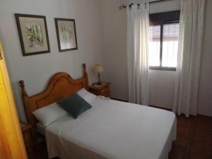 1 dormitorio con cama blanca y ventana en PUNTA SOL, en Isla del Moral