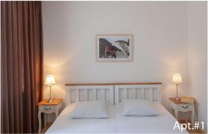1 dormitorio con 2 camas, 2 lámparas y una foto en la pared en svaneti apartment's, en Mestia