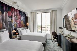 伯明翰Daxton Hotel Birmingham, Curio Collection by Hilton的有两张床和一扇窗户的酒店房间