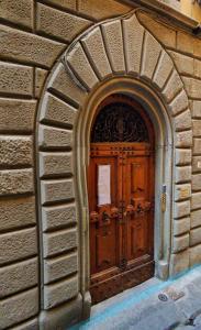 una puerta de madera en una pared de ladrillo con un arco en Strange Uncle B&B, en Florencia
