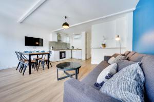 ein Wohnzimmer und eine Küche mit einem Sofa und einem Tisch in der Unterkunft Central Avignon Netflix Nespresso Wifi Appart Hôtel Avignon in Avignon