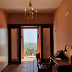 a room with a desk and a door with a view at Albergo Palazzo Sant'Anna in Gerace