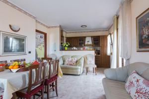 eine Küche und ein Wohnzimmer mit einem Tisch und einem Sofa in der Unterkunft Il Corallo in Porto Torres