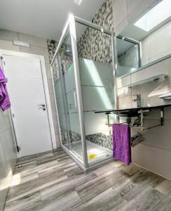 y baño con ducha acristalada y lavamanos. en Apartamentos Las Calas, en Santander