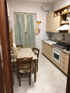 eine Küche mit einem Tisch und Stühlen sowie eine Küche mit einem Herd in der Unterkunft '' LA CASA DI CICI'' in Lavagna