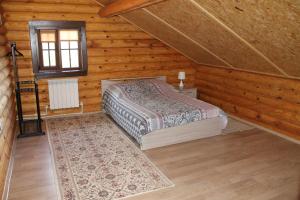 a bedroom with a bed in a wooden cabin at Guest House Lyubyatovo in Pskov