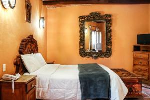 a bedroom with a bed and a mirror on the wall at Mirador del Frayle in San Miguel de Allende