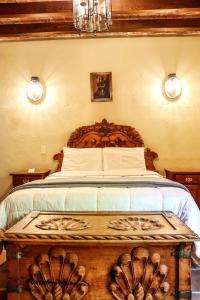 a bedroom with a large bed with a wooden headboard at Mirador del Frayle in San Miguel de Allende