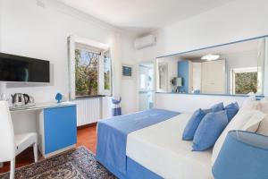 um quarto azul e branco com uma cama e uma secretária em Villa Maresca B&B em Piano di Sorrento
