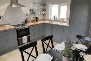 a kitchen with a table and chairs and a stove at Derrie Farm Cottage in Newton Stewart