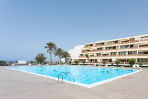 a large swimming pool in front of a hotel at Listen the ROCKS in Costa Del Silencio