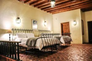 a bedroom with a bed and two chairs at Mirador del Frayle in San Miguel de Allende