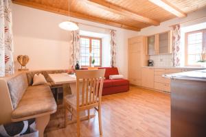eine Küche und ein Wohnzimmer mit einem Tisch und einem Sofa in der Unterkunft Brugger Hof in Feldthurns