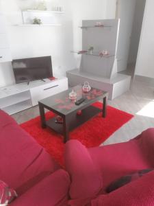 a living room with a red couch and a coffee table at Quintinha dos Queiroses in Vila Boa de Quires