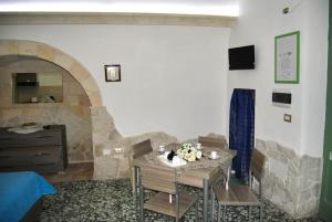 a living room with a table and a stone fireplace at La Casetta in Oria