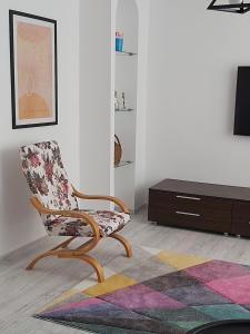 a living room with a chair and a table at Chic Apartament in Deva