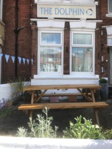a wooden picnic table in front of a building at Dolphin Guesthouse in Scarborough
