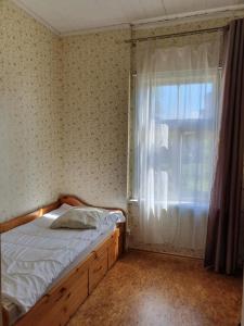 a small bedroom with a bed and a window at Summer cottage in Jurmala in Jūrmala